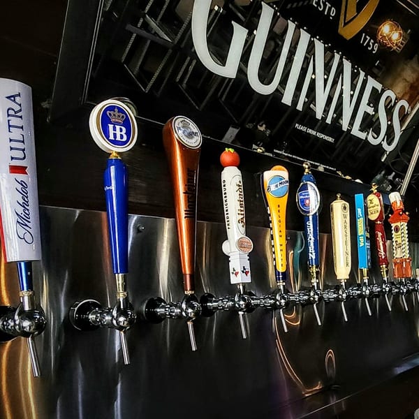 A row of beer taps with various brand handles, including Guinness, at Silver Creek Beer Garden & Grille.